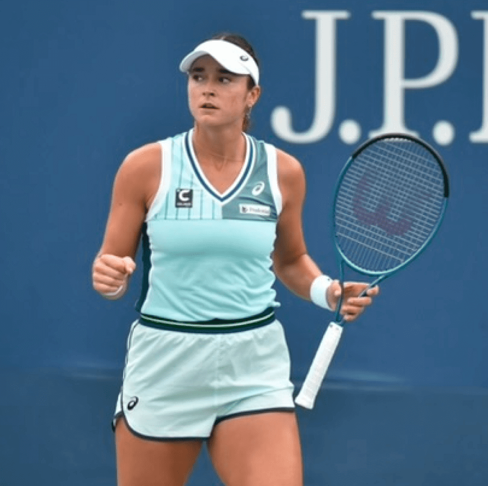 Female tennis player celebrating on court with racket in hand.