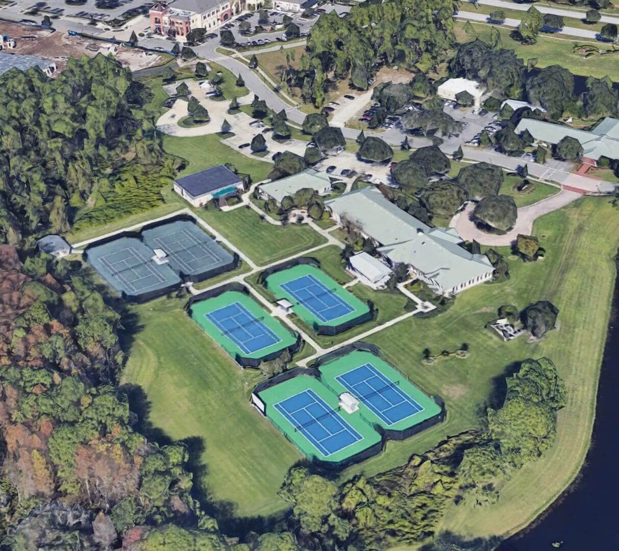 Aerial view of a park with tennis courts and buildings.