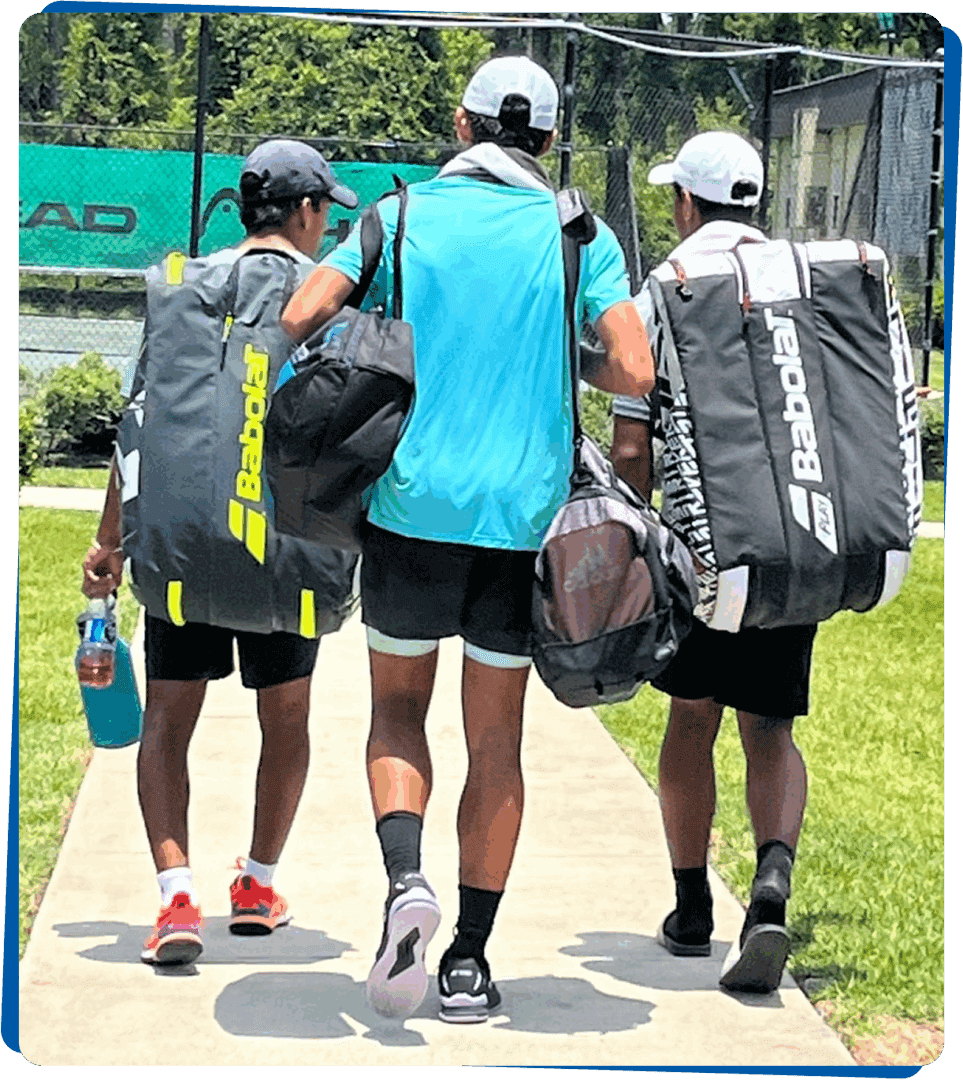 Three athletes walking with sports gear and water bottles outdoors.