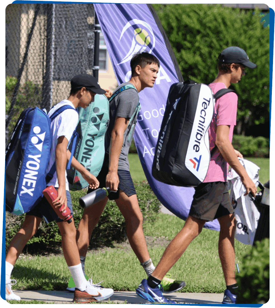 Three young golfers walking with their golf bags on a sunny day.
