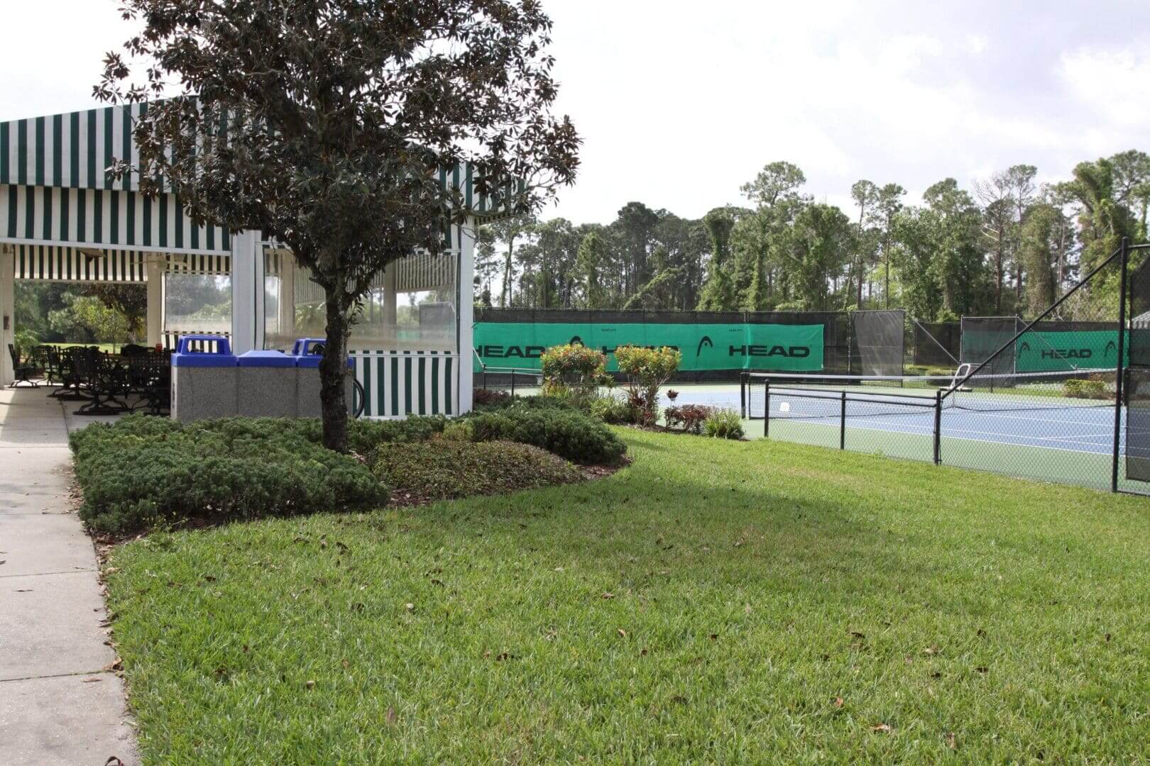 Entrance to a park with a welcome sign and green lawn.