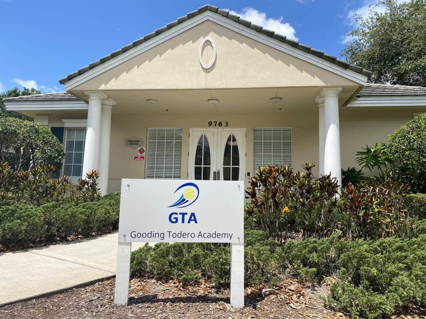 Entrance of a white building with a sign for Gooding Trades Academy.