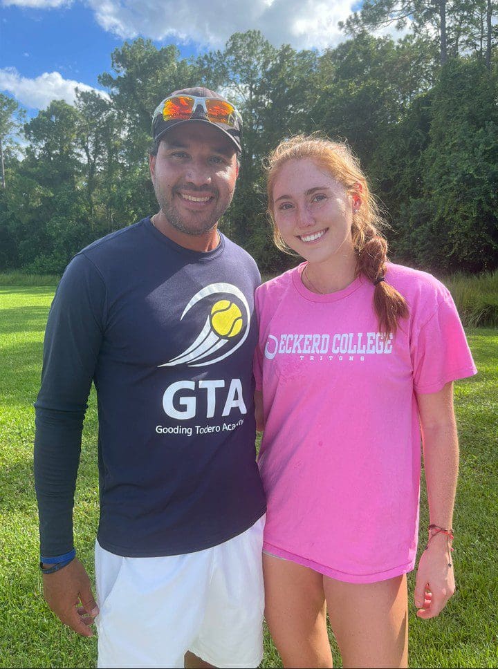 Two people smiling outdoors in casual clothing.