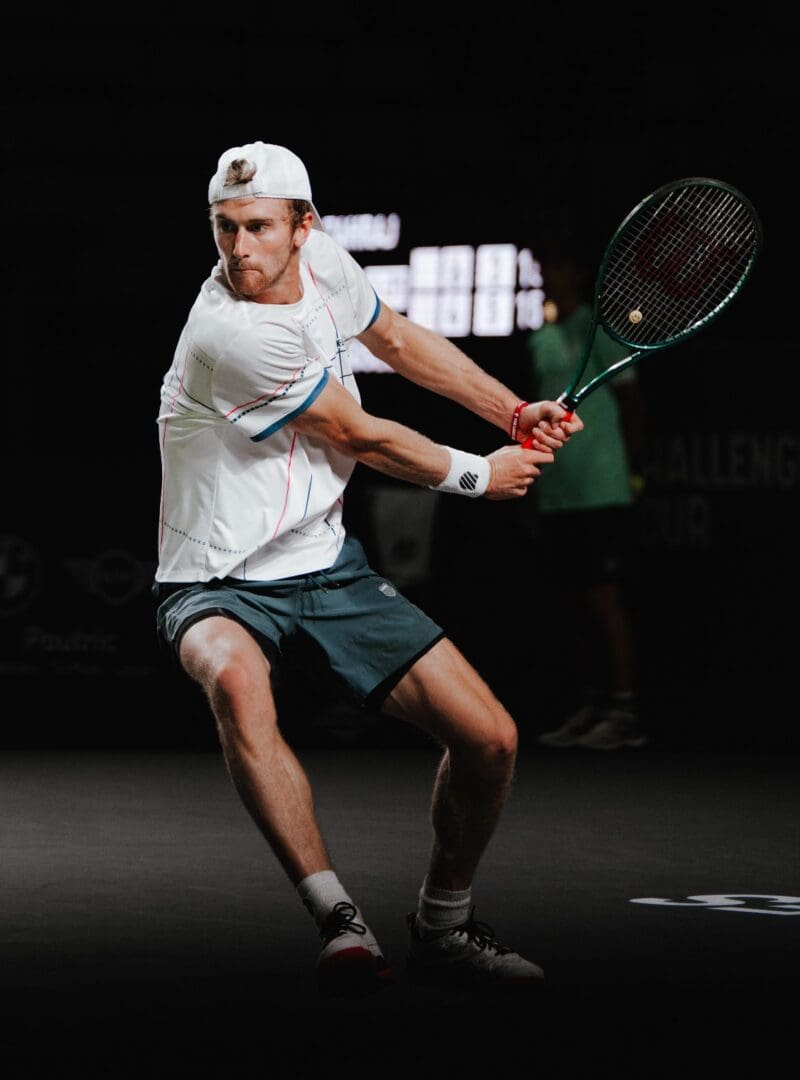 Tennis player preparing to hit backhand shot.