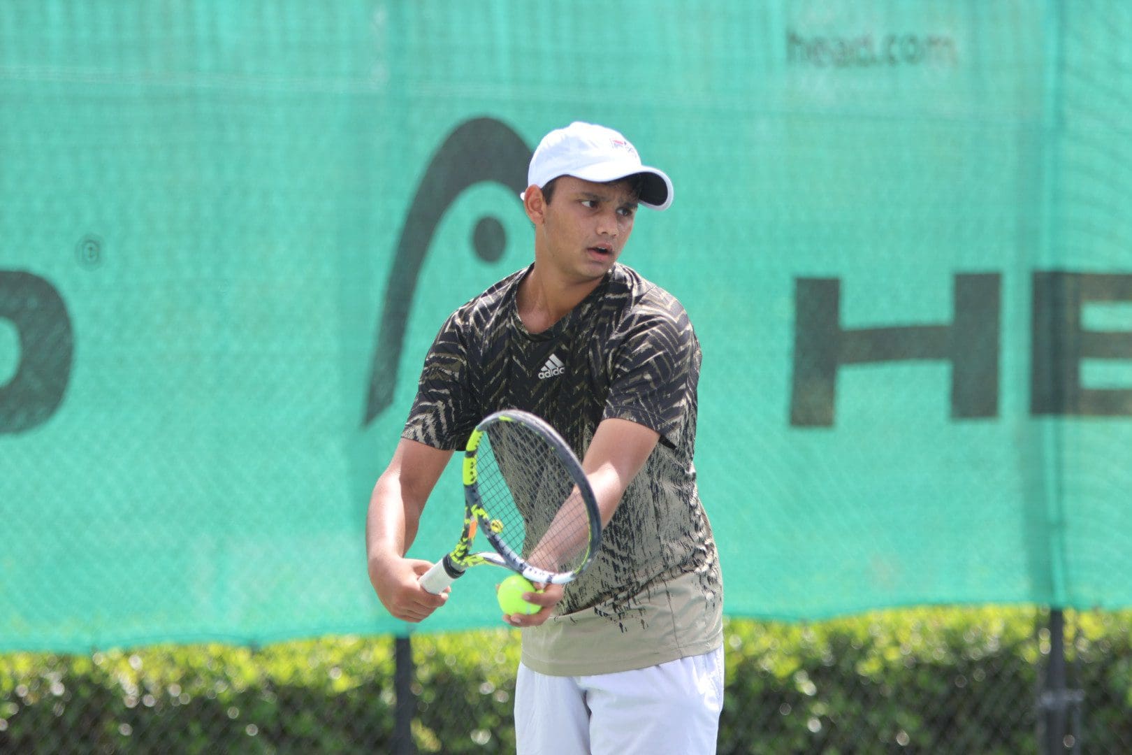 Male player in white cap holding ball