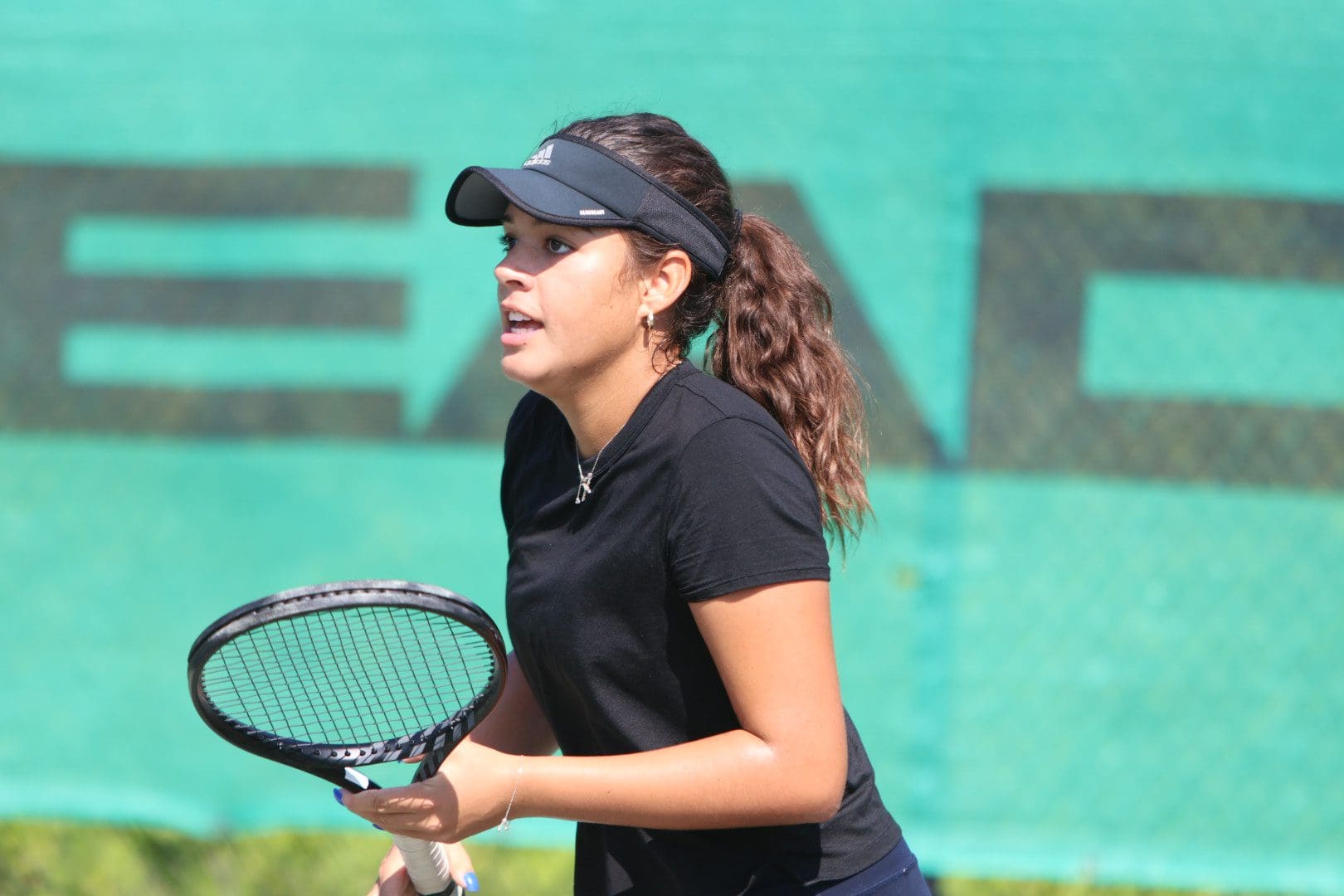 Female player with visor preparing return