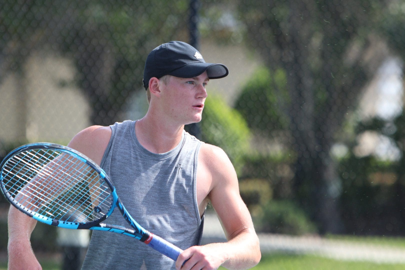Man playing tennis wearing a cap.