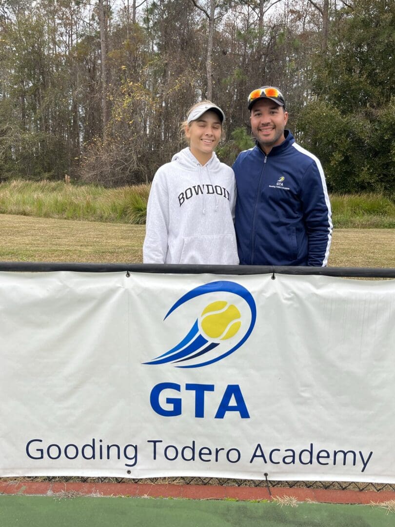 Two people smiling at tennis academy.