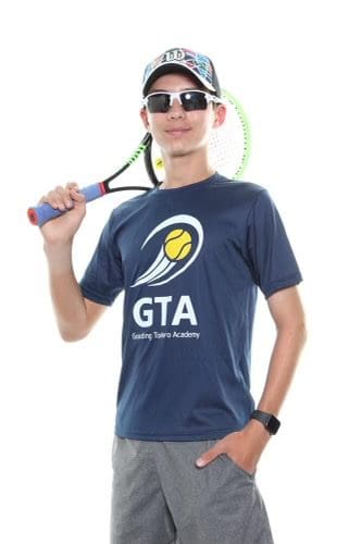 Person holding tennis racket, wearing sunglasses.