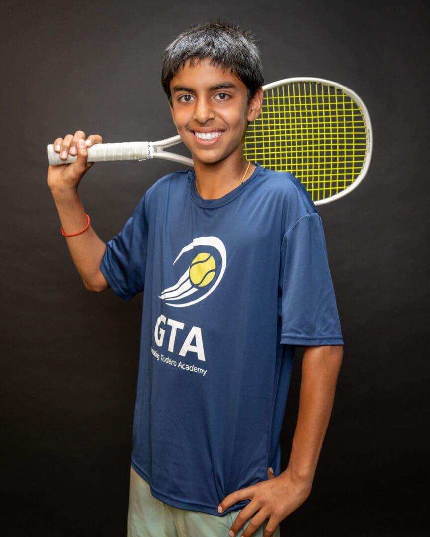 Teen boy smiling with tennis racket