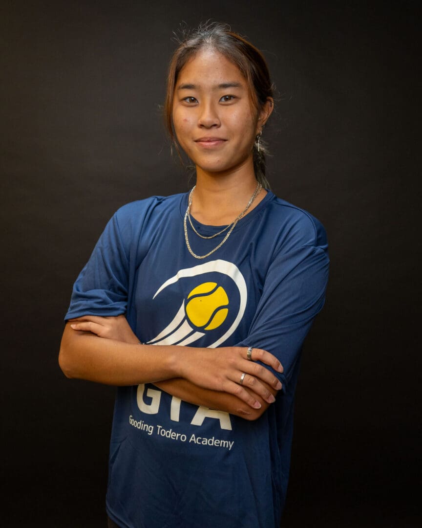 Person in blue tennis academy shirt