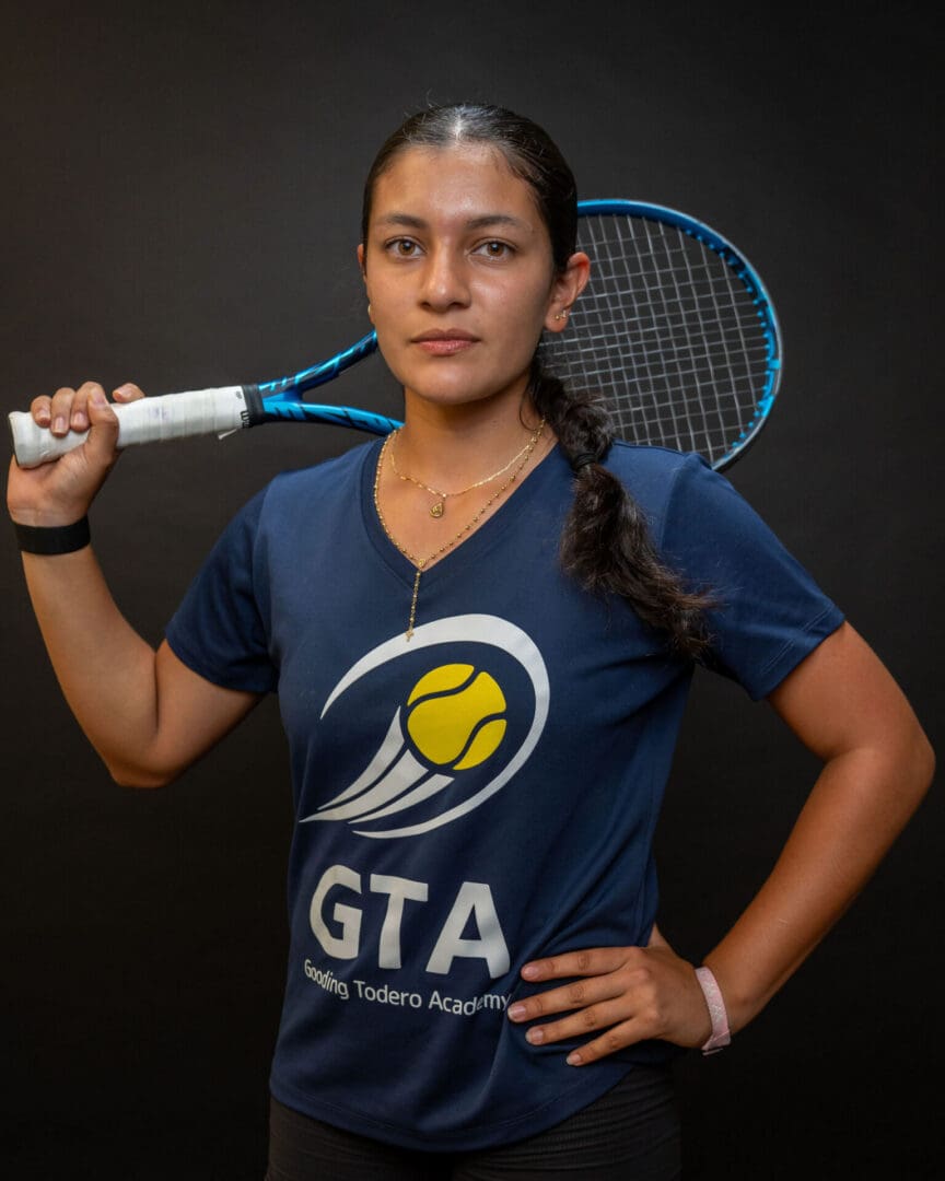 Woman tennis player holding racket over shoulder