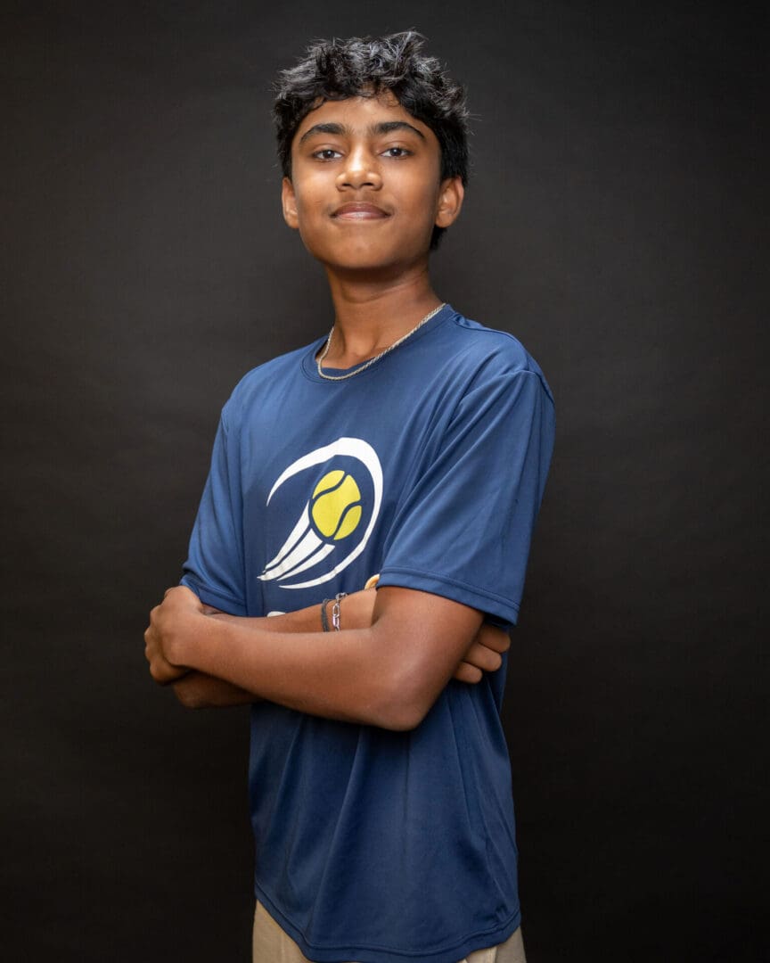 Teenager in blue sports shirt, arms crossed