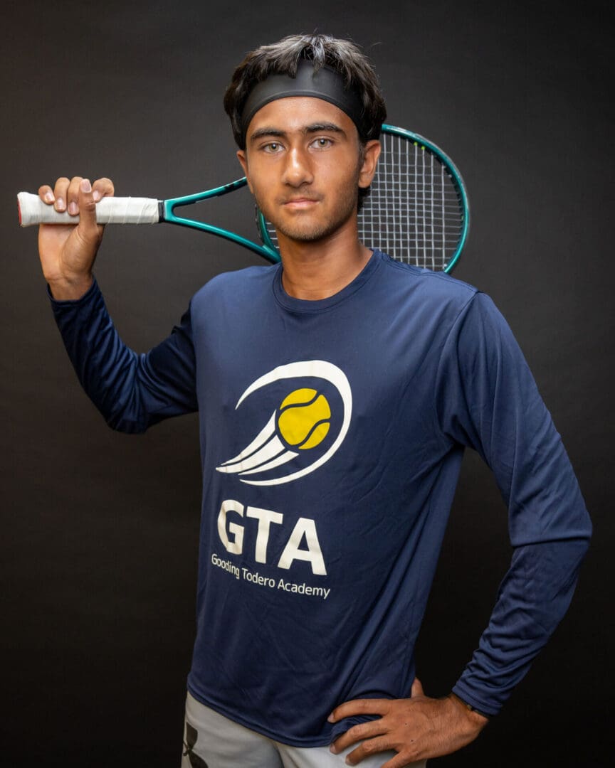 Tennis player posing with racket over shoulder